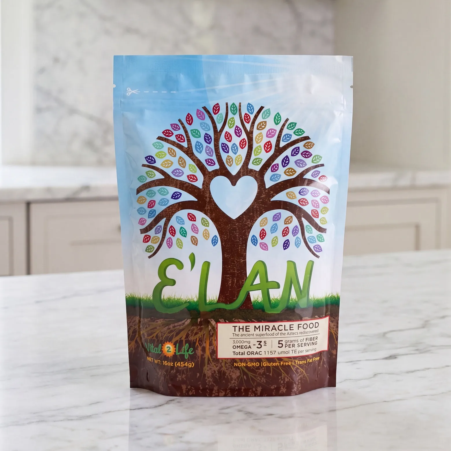 The E'LAN pouch standing on a white marble kitchen counter: a tree with a heart-shaped gap in its canopy and multicoloured leaves, over grass and soil, with E'LAN in green script and the Vital2Life mark below.